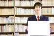 Foto: 図書室でメッセージボードを持っている男子中学生 図書室でメッセージボードを持っている男子中学生
