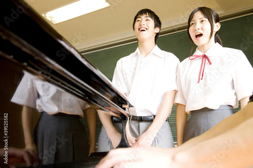 Photo: ピアノに合わせて歌う中学生男女 ピアノに合わせて歌う中学生男女