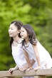 橋の上から景色を眺める女の子と若い女性