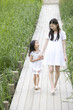 手を繋ぎ歩く女の子と若い女性