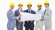 Close-up of smiling business people wearing safety helmets holding a map