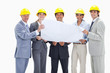 Smiling business people wearing safety helmets holding a map