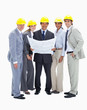 Smiling business people with safety helmets holding construction plans
