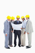 Business people wearing safety helmets watching a construction plan