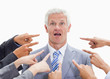 Shocked businessman with fingers being pointed at him