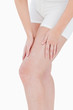 Woman in underwear massaging her thigh