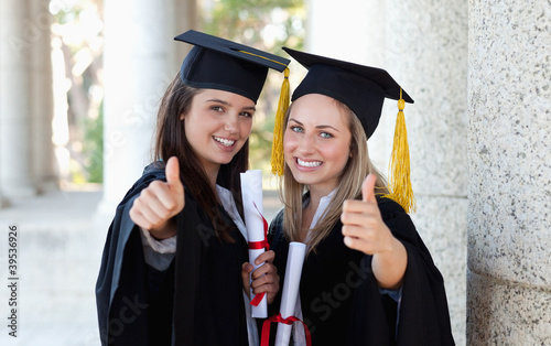 Photo: Smiling graduating students putting their thumbs up Smiling graduating students putting their thumbs up