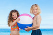Siblings together with their beach ball on the beach