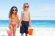 Children with sunglasses standing on the beach
