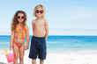 Children with sunglasses standing on the beach together