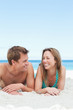Happy couple lying on the beach