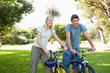 Couple standing with their bikes in the park
