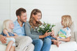 A mother smiles with joy as she is given a bouquet of flowers 
