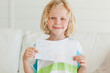A smiling boy holds up his letter to santa