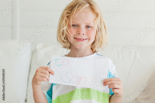 Photo: A smiling boy holds up his letter to santa A smiling boy holds up his letter to santa