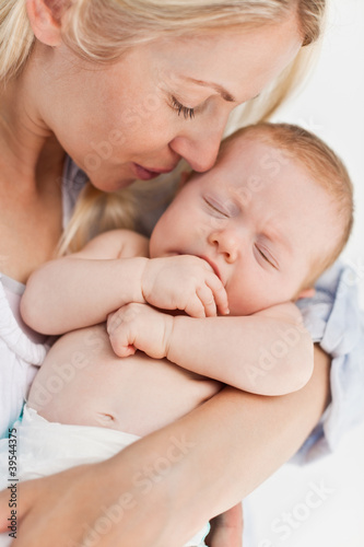 Photo: Close up of mother holding her sleeping baby Close up of mother holding her sleeping baby