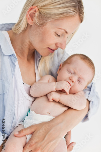 Photo: Mother holding her sleeping little baby Mother holding her sleeping little baby