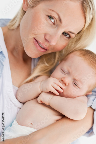 Photo: Close up of woman holding her sleeping baby Close up of woman holding her sleeping baby