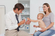 Little baby extending her hand while being examined by the doctor