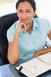 Foto: Thoughtful secretary looking at the camera with her chin resting on her hand Thoughtful secretary looking at the camera with her chin resting on her hand