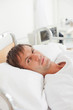 Serious patient looking at the camera while lying in a hospital bed