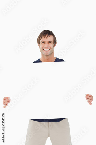 Photo: Smiling man holding a blank poster Smiling man holding a blank poster
