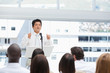 Serious businessman gesturing towards an audience