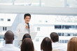 Businessman fixing his tie while being watched by an audience