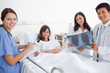 Foto: Smiling doctors looking ahead as they hold an x-ray scan with a patient Smiling doctors looking ahead as they hold an x-ray scan with a patient