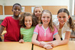 Smiling students together behind desk