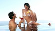 Couple in a swimming pool drinking cocktails