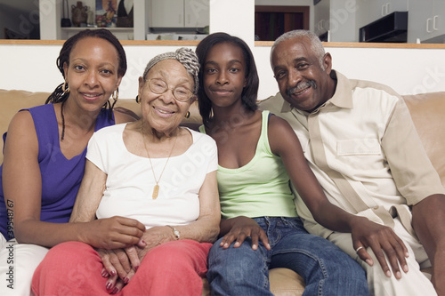 Photo: Couple sitting with their teenage daughter and mother in-law on a couch Couple sitting with their teenage daughter and mother in-law on a couch