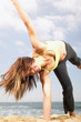Woman doing cartwheel at beach