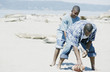 Father and son playing football on the beach