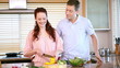 Woman chopping peppers in front of her boyfriend