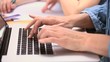 Hands typing on a laptop