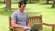 Video: Camera rises to show a man typing on a laptop while wearing headphone Camera rises to show a man typing on a laptop while wearing headphone