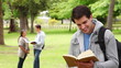 Video: Man laughing while turning the page of a book before looking at the camera Man laughing while turning the page of a book before looking at the camera