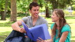 Video: Two friends laughing while pointing at a folder as they sit together Two friends laughing while pointing at a folder as they sit together