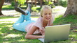 Video: A woman lies in the park with her laptop as she laughs and then looks at the camera A woman lies in the park with her laptop as she laughs and then looks at the camera