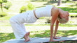A woman performs a yoga position as the camera changes to a side view
