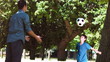 Boy playing soccer in slow motion with an adult