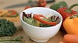 Vegetables dropping into bowl in super slow motion