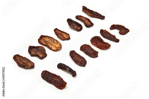 Photo: Sun dried tomato's isolated on a white background. Sun dried tomato's isolated on a white background.