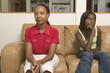 Mother and teenage daughter sitting on couch