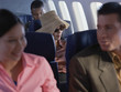 Young woman relaxing on airplane with hat and sunglasses