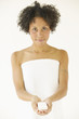 Portrait of woman wrapped in towel holding soap