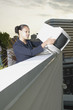 Businesswoman dropping computer monitor over balcony