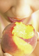 Photo: Close up of woman biting peach Close up of woman biting peach