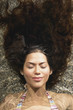 Woman floating in water with eyes closed